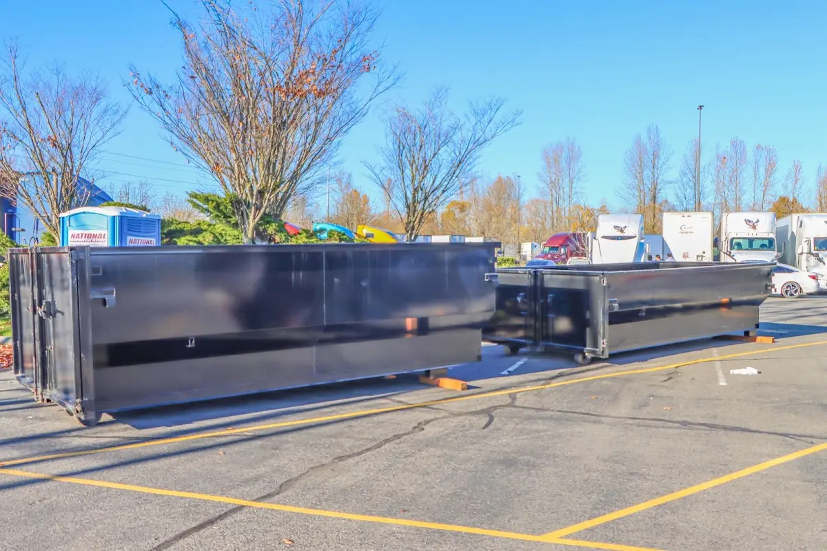 Professional dumpster rental service with roll-off container on residential driveway in Montclair